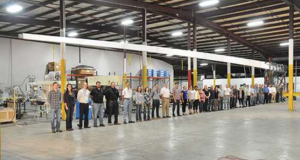 Photo of CRG and NONA composites employees under the lightweight composite boom built for the REACH program